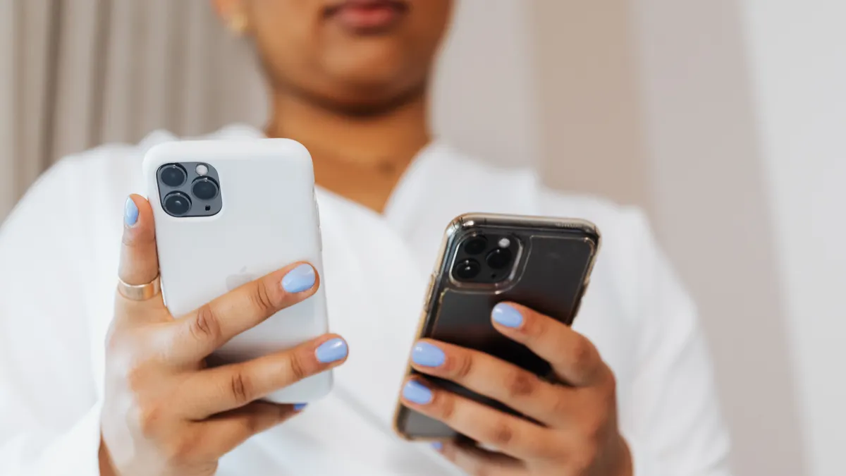 person holding two smartphones
